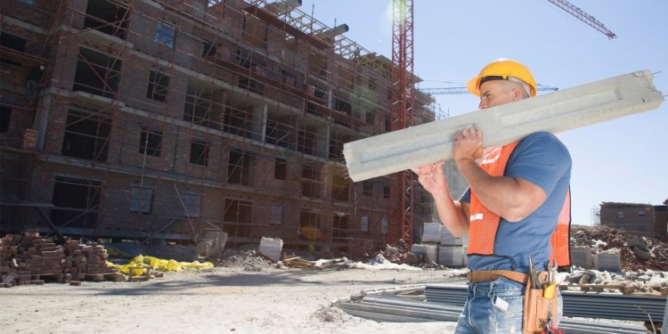 Contractor lifting a beam at a