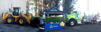 an picture of a Teichert hiring kiosk at a conference with trucks into the background