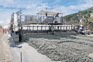 When working with smaller slipform pavers a spreader auger spreads the concrete ahead of the front side metering screed, behind that the concrete profile is created
